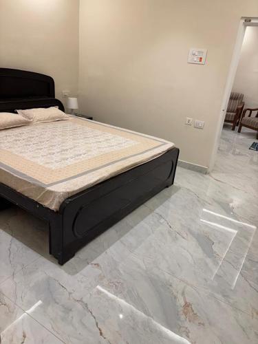a bed in a bedroom with a marble floor at Visitors Lounge by MMG - 2&3BHK Furnished - Rd 12 Banjara Hills in Hyderabad