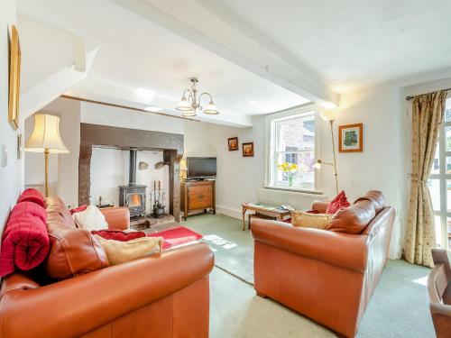a living room with two leather couches and a fireplace at Hollow Creek Cottage - 28012 in Rockcliffe