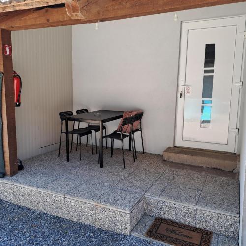 a table and chairs in a room with a door at Apartma Kolpa Krasinec in Gradac