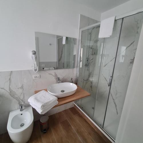 a bathroom with a sink and a shower and a toilet at Asmundo Palace Suites & Spa in Catania
