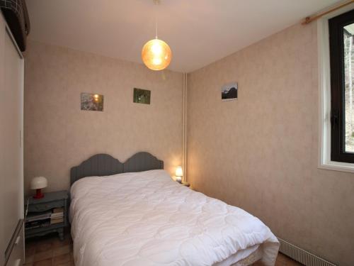 - une chambre avec un grand lit et une couette blanche dans l'établissement Appartement T2 avec balcon, parking et WIFI au Mont-Dore - FR-1-608-141, à Le Mont-Dore