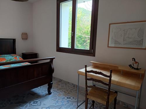 a bedroom with a bed and a desk and a window at That's amore - l'incanto della valle 