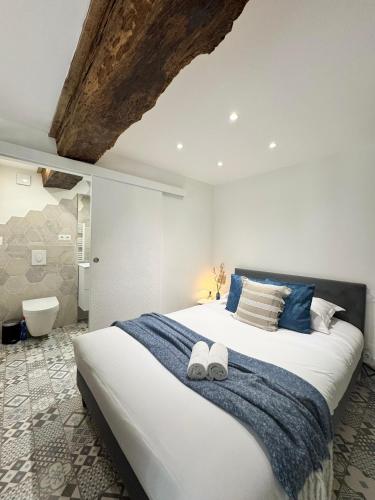 une chambre avec un grand lit avec deux serviettes dessus dans l'établissement Le Petit Contour, Hyper centre de Rennes, à Rennes