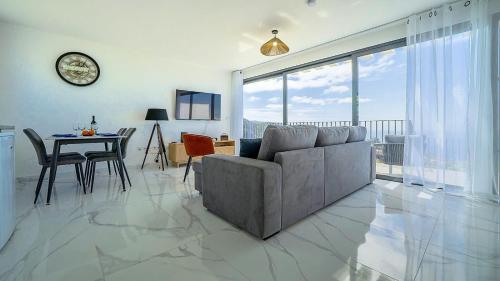 a living room with a couch and a table at CASA PANORAMA SOL- NEW VILLA WITH HEATED SALTWATER POOL and FANTASTIC SEA VIEW in Ponta do Sol