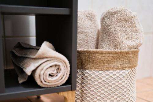 a basket filled with towels on a shelf at Bright City Apartment Free Parking & 2 Min to Subway in Vienna