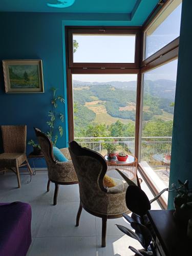 a room with chairs and a table and a large window at That's amore - l'incanto della valle 
