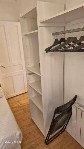 un placard blanc avec une chaise noire dedans dans l'établissement Suite Cosy Gare&TNB à 200 m - 3 personnes - Rennes, à Rennes