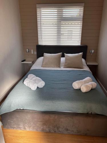 a bed with two pillows and two towels on it at 43 Harbour View in Poole