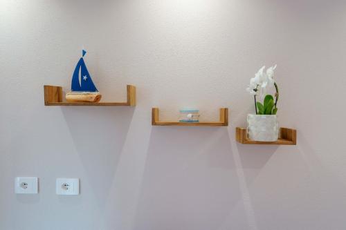 a wall with two wooden shelves with a boat on it at La Rosa dei Venti Guesthouse in Villasimius