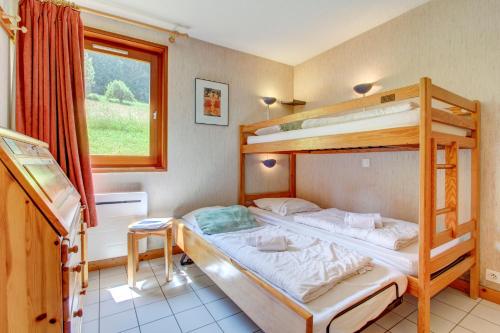 une chambre avec deux lits superposés et une fenêtre dans l'établissement PICARON A13, à Morzine