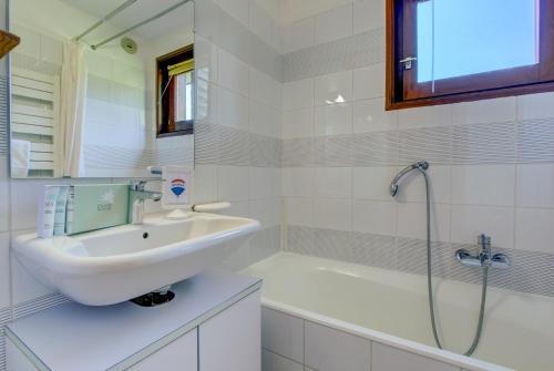 une salle de bain blanche avec un lavabo et une douche dans l'établissement PICARON A13, à Morzine
