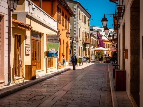 a man walking down a cobblestone street at Agora Bed & Breakfast in Vlorë