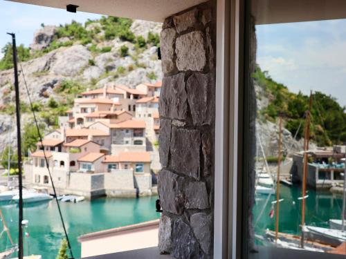 a window with a view of a harbor at Portopiccolo Apartments in Sistiana