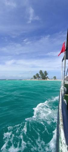 a boat in the water with an island in the background at Rooms on San Blas Islands Icodub in Panama City