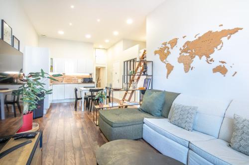 a living room with a couch and a world map on the wall at Le Coconfort - Gare - Centre Ville in Voiron