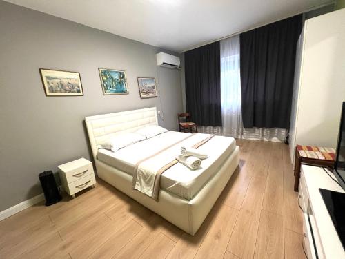 a bedroom with a white bed and a window at Downtown Retreat "Spiranca" in Tirana