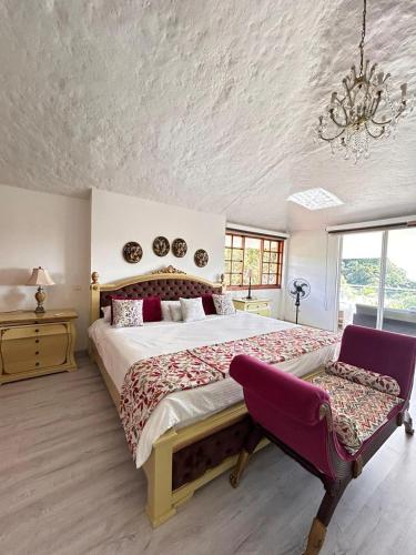 a large bedroom with a large bed and a chandelier at Casa Caballero Hotel Boutique in Salento