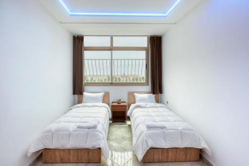 una fila de camas en una habitación con ventana en White Majorelle Mar, en Agadir