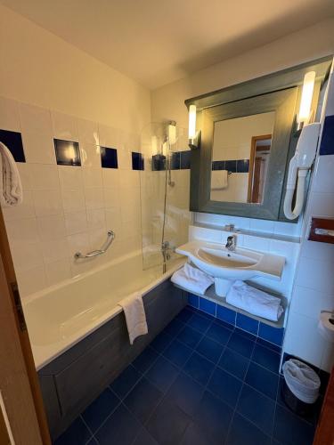 une salle de bain avec un lavabo, une baignoire et un miroir dans l'établissement 2 Bedroom Apartment Arc 1950 - Sources de Marie, à Arc 1950