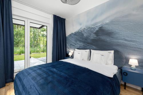 een slaapkamer met een groot bed met een golf aan de muur bij Apartamenty Baltic Marina in Międzywodzie