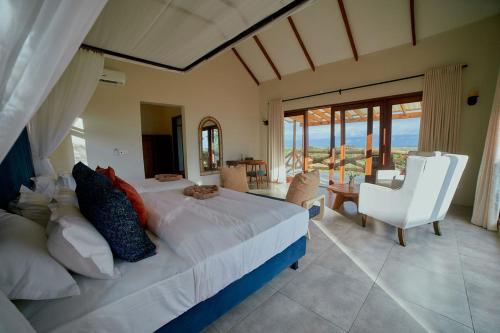 a bedroom with a large bed with a view of the ocean at Tarangire Luxury Hideaway in Mbesi