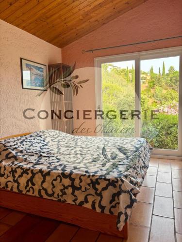 une chambre avec un lit et une grande fenêtre dans l'établissement Villa Lavande, à La Londe-les-Maures