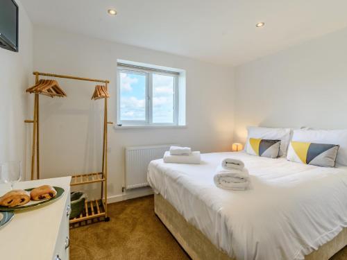 a bedroom with a large bed with towels on it at 3 bed in Bamburgh 79178 in Belford