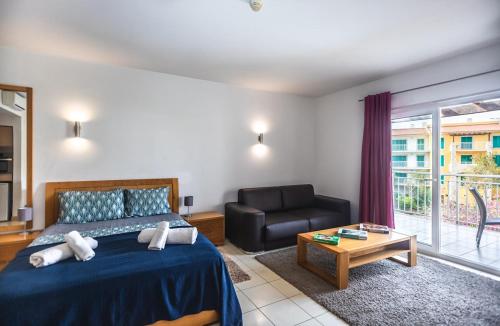 una camera da letto con un letto, un divano e un tavolo di KÁ RICARDO - STUDIO 206 Vila Verde a Santa Maria