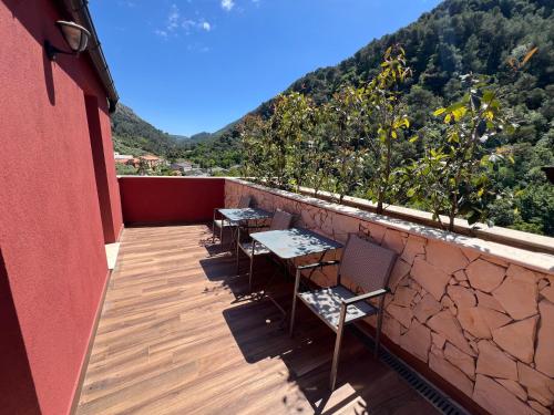 two tables and chairs on a balcony with a mountain at Domaine Baccia Donna Proche Nice, Climatisation, Jacuzzi chauffé, Pétanque & Parking gratuit in La Trinité
