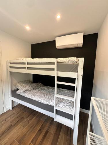 a bunk bed room with two bunk beds in it at Domaine Baccia Donna Proche Nice, Climatisation, Jacuzzi chauffé, Pétanque & Parking gratuit in La Trinité