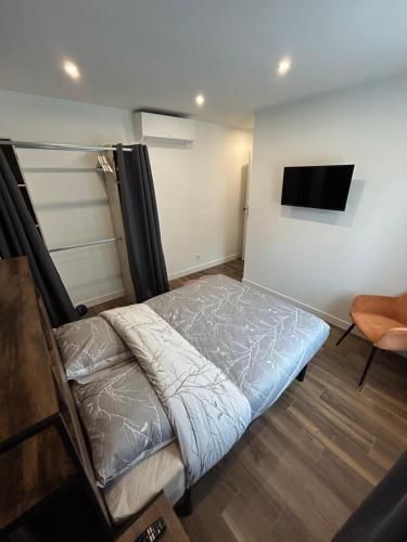 a bedroom with a bed and a flat screen tv at Domaine Baccia Donna Proche Nice, Climatisation, Jacuzzi chauffé, Pétanque & Parking gratuit in La Trinité