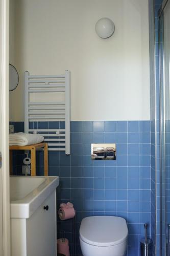 La salle de bains est pourvue de carrelage bleu, de toilettes et d'un lavabo. dans l'établissement Flat La Croisette Cannes La Croix d'Or 2, à Cannes