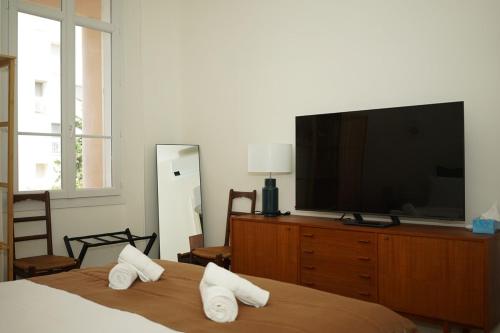 - une chambre avec une télévision à écran plat et un lit dans l'établissement Flat La Croisette Cannes La Croix d'Or 2, à Cannes