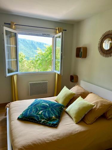 a bedroom with a bed with a large window at L'ostal de la Patz in Saint-Julien-de-la-Nef