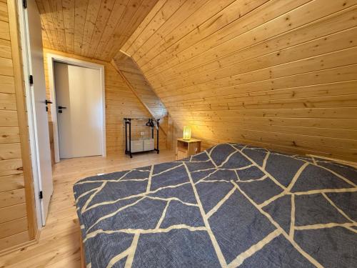 a bedroom with a bed in a wooden room at Bociani Zakątek nad jeziorem in Leszczewo