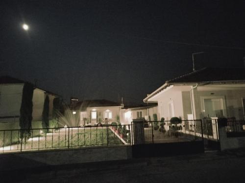 a white house at night with a fence at Kariofilli's house in Áyios Athanásios