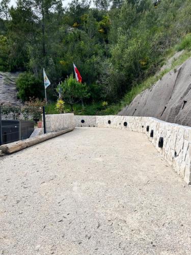 a stone wall with two flags on top of it at Domaine Baccia Donna Proche Nice, Climatisation, Jacuzzi chauffé, Pétanque & Parking gratuit in La Trinité