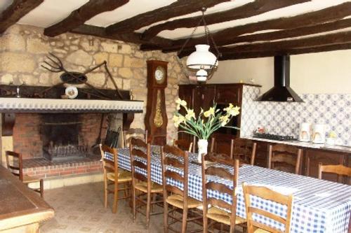 une salle à manger avec une table et des chaises et une cheminée dans l'établissement logis du port, à Domme