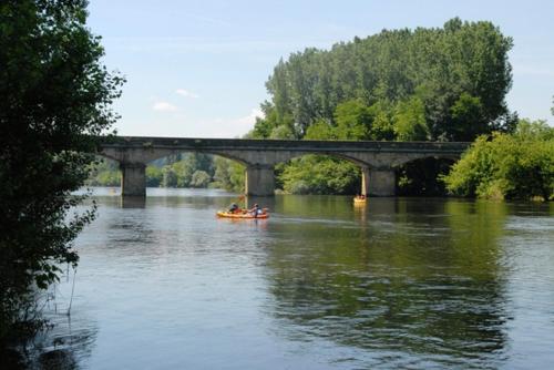 un groupe de personnes dans un bateau sur une rivière sous un pont dans l'établissement logis du port, à Domme