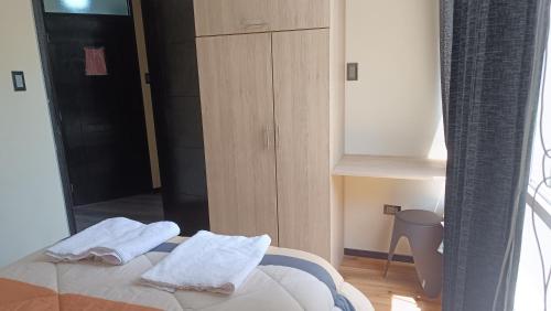 a bedroom with a bed with two towels on it at Aparments Av La Paz in Arequipa