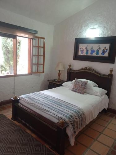 a bedroom with a large bed and a window at Casa Caballero Hotel Boutique in Salento