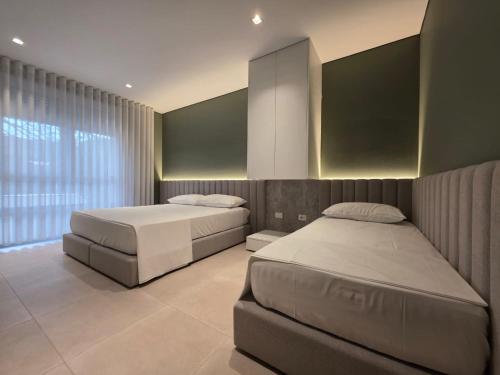 a bedroom with two beds and a large window at Blue Harmony in Lalzit Bay