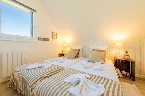 deux lits avec des serviettes dessus dans une chambre dans l'établissement Le Clos des Brises, à Houlgate