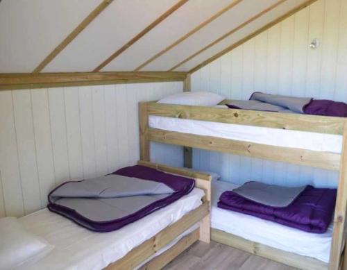 Cette chambre mansardée comprend 3 lits superposés. dans l'établissement Camping 4 étoiles - Piscine - ccbahgh, à Secondigny
