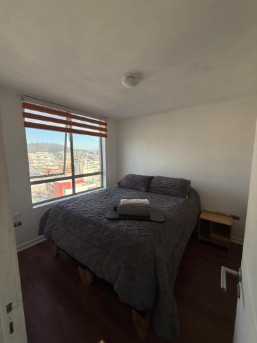 a bedroom with a bed and a large window at Vista Panorámica gran Concepción in Concepción