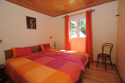 een slaapkamer met een kleurrijk bed en een raam bij Casa Daniela in Calheta