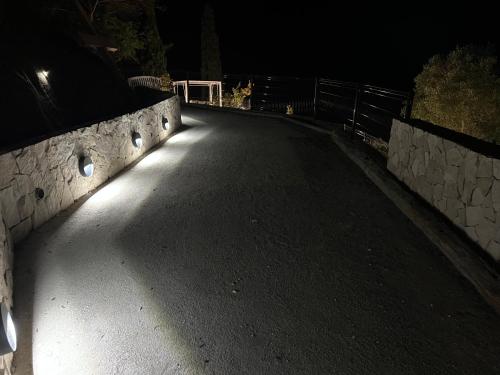 an empty road at night with a fence and a gate at Domaine Baccia Donna Proche Nice, Climatisation, Jacuzzi chauffé, Pétanque & Parking gratuit in La Trinité