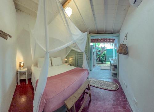 a bedroom with a bed with a mosquito net at Barrinha dos Ventos Barrinha de Baixo Ceara Quartos Casas Kitesurf in Acaraú