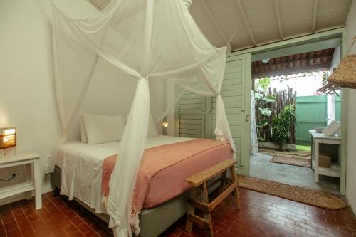 a bedroom with a bed with a canopy at Barrinha dos Ventos Barrinha de Baixo Ceara Quartos Casas Kitesurf in Acaraú