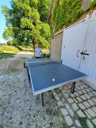 un homme debout devant une table de ping-pong dans l'établissement Domaine de l'Atrée - Tente Maasaï Poyaudine, à Saint-Martin-des-Champs